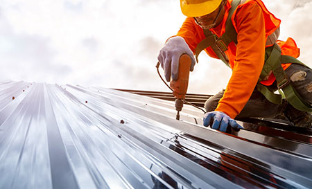 image of a roofer installing solar panels on a roof